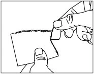 Two hands holding and carefully peeling off a rectangular piece of material or a plaster from a flat surface