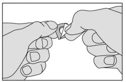 Due mani che afferrano e aprono con delicatezza un piccolo contenitore o blister medico per aprirlo correttamente