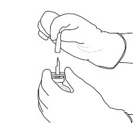Two gloved hands open a medicine vial inserting a
