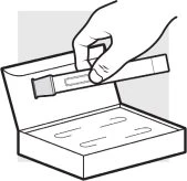 Una mano tiene un contenitore cilindrico sopra una scatola aperta che contiene altri due contenitori simili disposti parallelamente