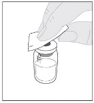 Una mano tiene un tampone per pulire il tappo di un flaconcino di vetro contenente un liquido chiaro