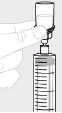 A hand holds an inverted glass vial above a graduated syringe to draw up the liquid contained inside