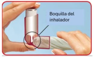 Due mani tengono un inalatore cilindrico con un ingrandimento che mostra la bocchetta del dispositivo per l