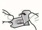 Two hands lifting the flap of a metallic package to remove a tablet from the central cavity of the blister