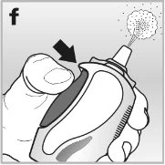 A hand pressing the thumb on the top of a medical device to activate the