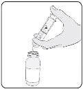 Una mano tiene una siringa pronta a prelevare il liquido da un flacone di vetro aperto con un ago