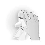 A hand holding a white medical device with a protective cap and a contoured base for application
