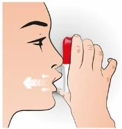Profile of a person using a spray medical device held in hand near the mouth, with a white vapor cloud emerging