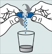 Two hands separating a blue capsule, releasing its granular content