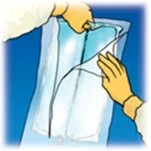 Two hands carefully opening a transparent plastic pouch containing a medical device against a deep blue background