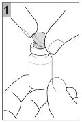 Two hands hold a small glass vial while one hand removes the top cap to prepare the medication