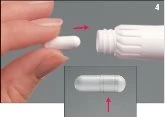 Una mano inserisce una capsula bianca in un contenitore cilindrico bianco con una freccia rossa che indica il movimento verso l'