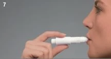 Una persona tiene un dispositivo medico bianco tra le dita e lo appoggia contro le labbra per l'