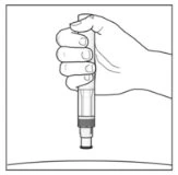 A hand holds vertically a cylindrical medical device with the tip pointing downward above a flat surface