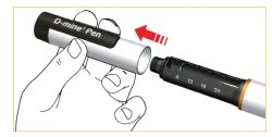Una mano impugna la parte superiore di una penna iniettiva O-mine Pen per inserirla nel corpo del dispositivo, indicato da una freccia rossa