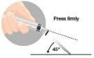Una mano impugna una siringa inclinata a 45 gradi rispetto a una superficie piana con la scritta Press firmly accanto alla freccia