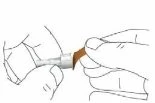 Two hands holding and applying a white and brown cylindrical medical device onto the skin of an arm or leg