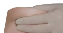 A hand with a white glove gently pressing with fingers on the skin surface of the abdomen or thigh