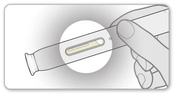 A hand holding an elongated medical device with a circular magnification showing yellow liquid inside