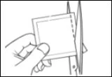 A hand holds a plastic pouch while a pair of scissors cuts the top edge to open it