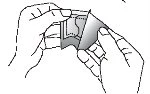 Two hands holding and carefully separating a medication package or plastic wrapper to extract the internal contents