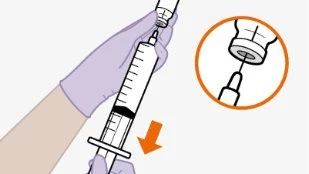 Una mano guantata preleva il liquido da un flacone con una siringa, con un dettaglio ingrandito dell'ago