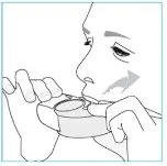 Black and white drawing of a person placing a tablet or medical device into their mouth, holding it with both hands