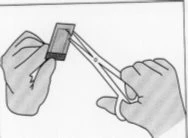 Due mani aprono una bustina rettangolare utilizzando un paio di forbici per estrarne il contenuto in un foglietto illustrativo medico