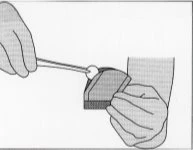 Due mani utilizzano un bastoncino per applicare una piccola quantità di crema sulla superficie di un applicatore piatto e rettangolare
