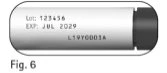 White capsule with black text indicating lot number 123456, expiration date JUL 2029, and code L19Y0003A on a gray background with a black cap