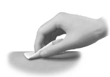 A hand gently applying a white patch onto smooth, flat skin surface