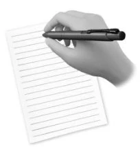 A hand holding a dark pen writing on a white lined sheet of paper tilted to the left