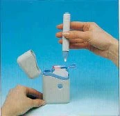 Una mano tiene una penna iniettiva bianca sopra un contenitore coordinato aperto su uno sfondo azzurro uniforme