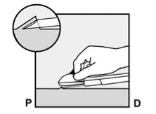 A hand pressing a medical device onto a flat surface with an enlargement showing the tip of the