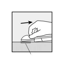 A hand pressing and moving a white medical device to the right on a flat surface following the direction of a black arrow