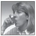 A woman with light hair holds an inhaler close to her mouth, ready to take the medication in a