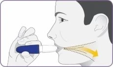 Profile of a person using an inhaler held in the right hand, with a yellow arrow indicating the drug passing into the throat