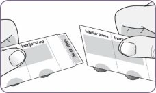 Two hands holding and separating two rectangular 33 mg Imbrija drug packages on a white background with rounded purple edges