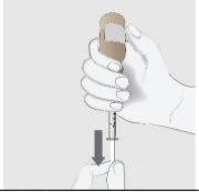 A hand holding a syringe with an upper device and a gray arrow indicating downward movement toward a finger placed underneath