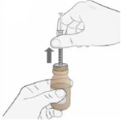 A hand holding a vial with liquid while the