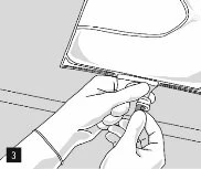 Two hands carefully holding and manipulating the bottom part of a medical package or bag to open it or remove the contents