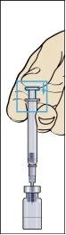 A hand holding a vertical syringe while the