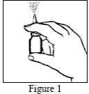 A hand holds a small bottle with a spray nozzle emitting a cloud of droplets toward the