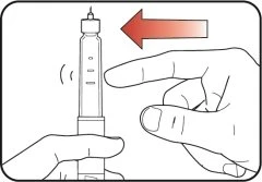 A hand holding a syringe while a finger presses laterally against the cylindrical body indicated by a red arrow pointing to the left