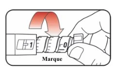 A hand rotates the upper part of a medical device downward to align the mark with the number 0 indicated by the label Marque