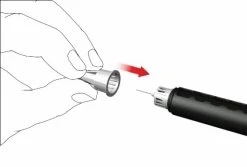 Una mano tiene un tappo cilindrico che viene avvicinato con una freccia rossa alla punta di un dispositivo medico nero a forma di penna