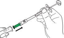 A hand inserting a syringe, indicated by a black arrow, into a white and green cylindrical container