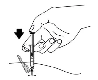 A hand holding a syringe and pushing it downward to insert the