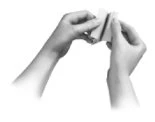 Two hands gently hold and fold a small light-colored rectangular container or wrapper on a white background