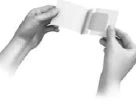 Two hands holding and opening a small rectangular medicine container or package against a white background